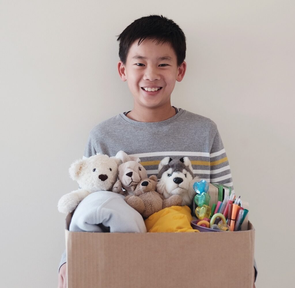 asian young volunteer preteen boy holding a box of beuznkj