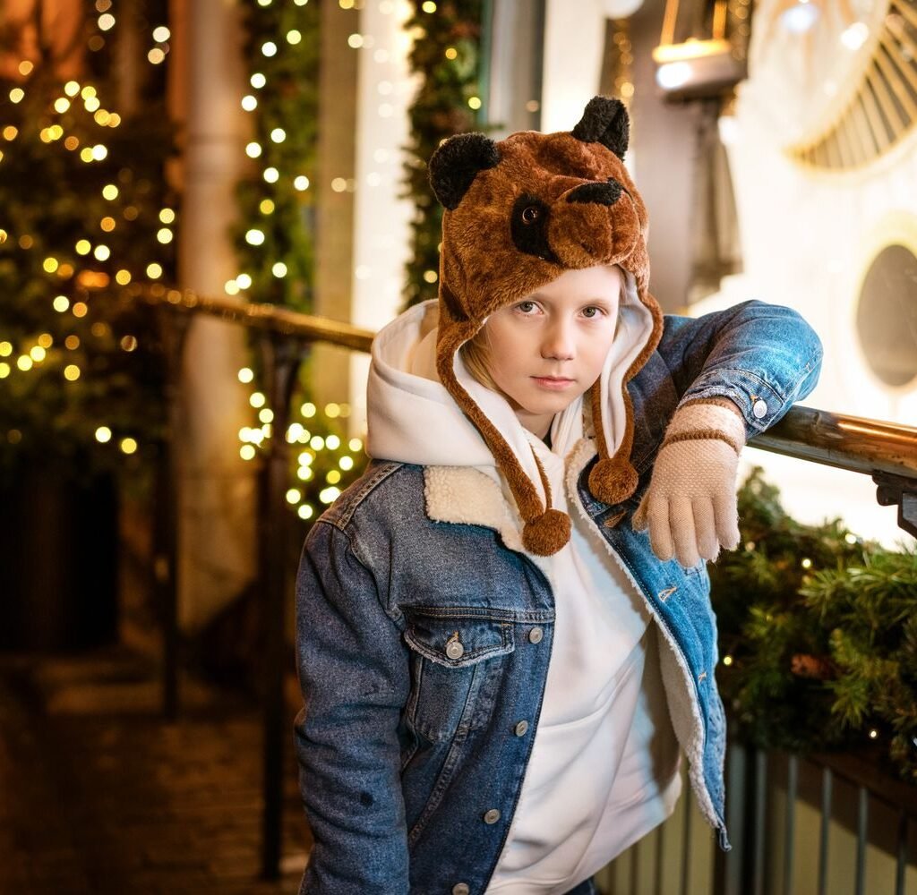 young guy posing by the christmas tree on the stre 68ufqvh